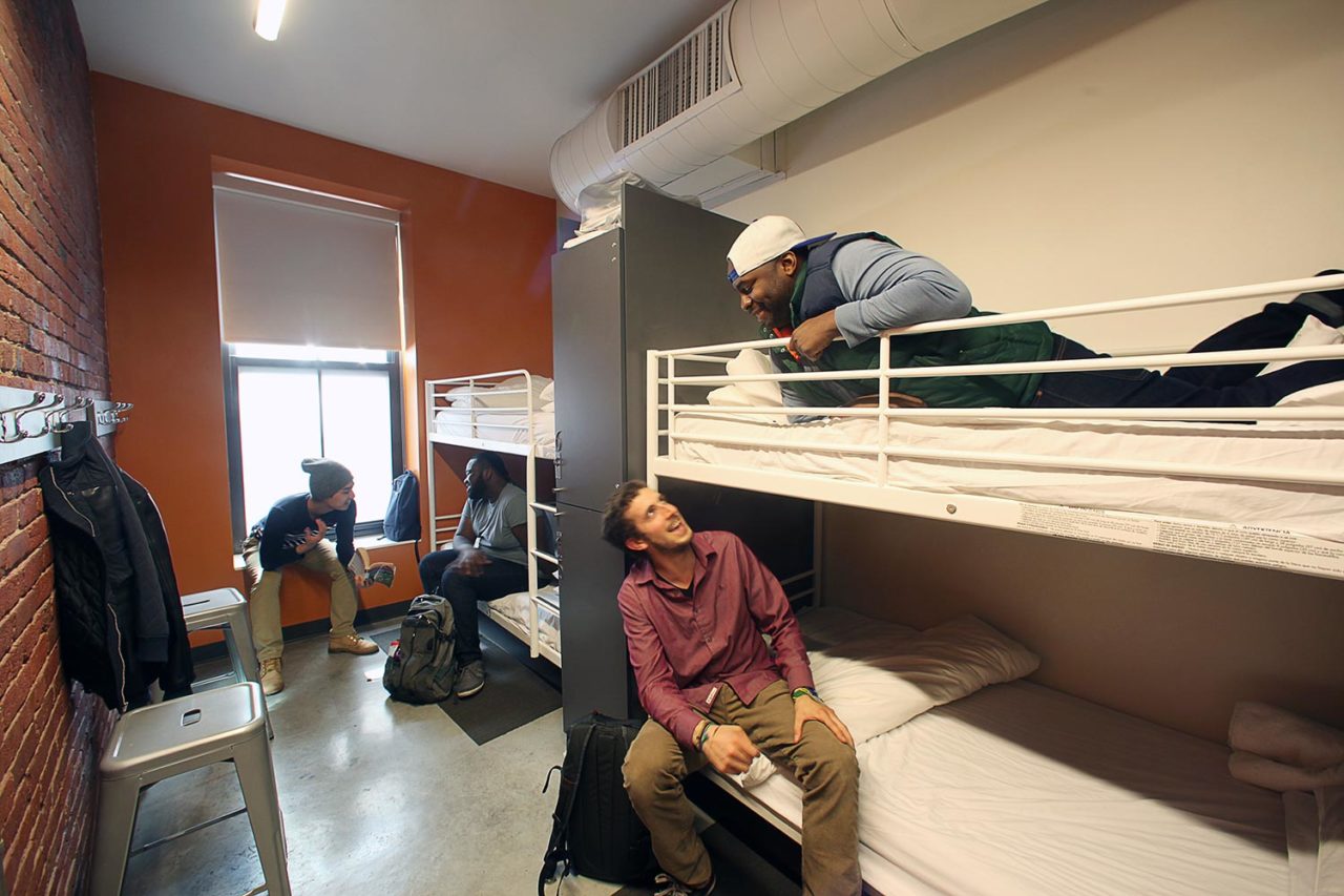 guests relax and talk in a 4-bed dorm room at HI Boston Hostel