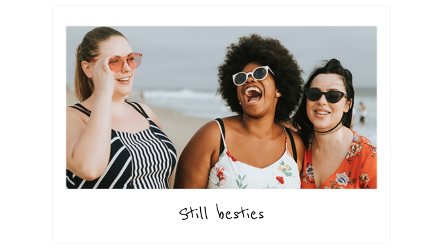 Three young women walking down the beach laughing