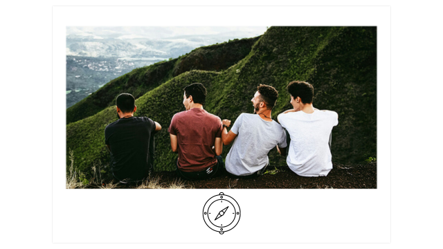 four male friends sit overlooking green mountains