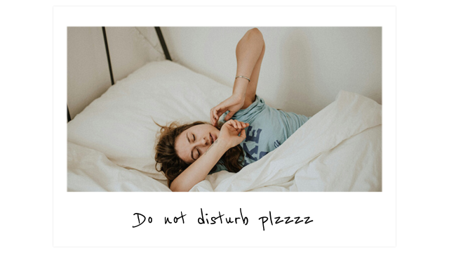 a woman lays in bed under the covers and stretches her arms