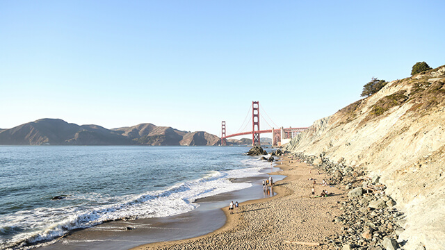 A view of China Beach, a small crescent of sand with a view of the golden gate bridge