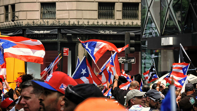 parade-goers wave Puerto Rican flags in New York City