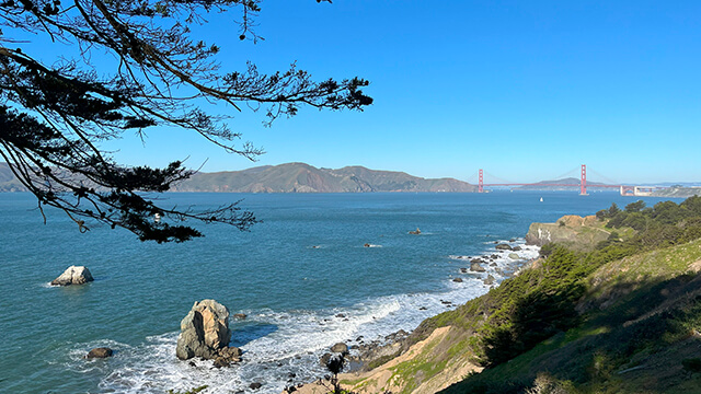 A view from Lands End in San Francisco looking out over the ocean and the San Francisco Bay. The Golden Gate bridge is in the background.